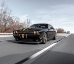 High-performance black car driving fast on a highway with dynamic motion blur.